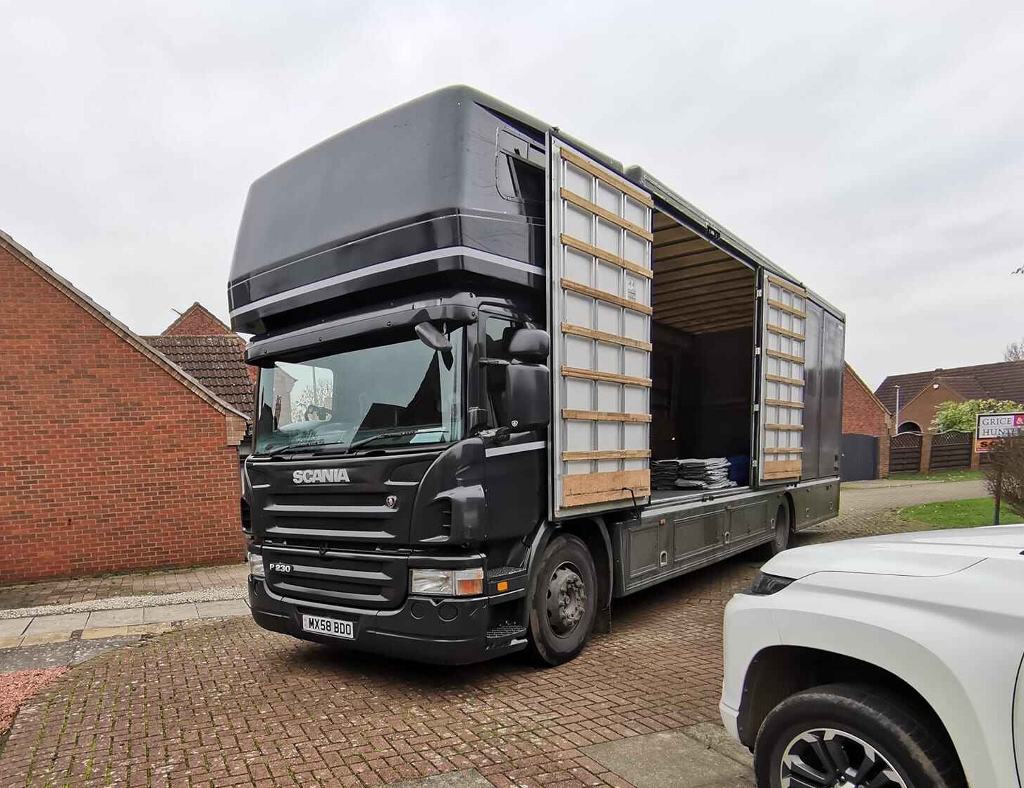 An Isle Of Man Removals Company Truck Outside of A Modern Brick House ready for a removals job